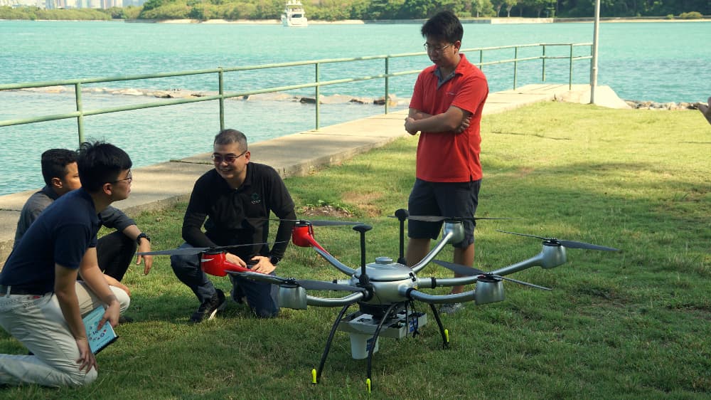 Instructors teaching students how to operate a drone and how it works